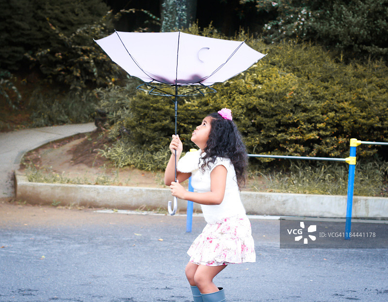 女孩玩着古怪的雨伞图片素材