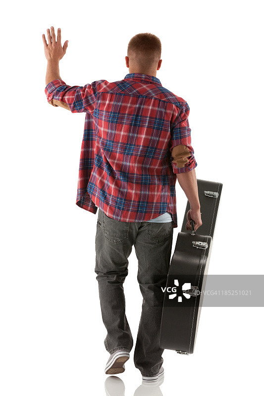后视图的街头音乐家走吉他盒图片素材