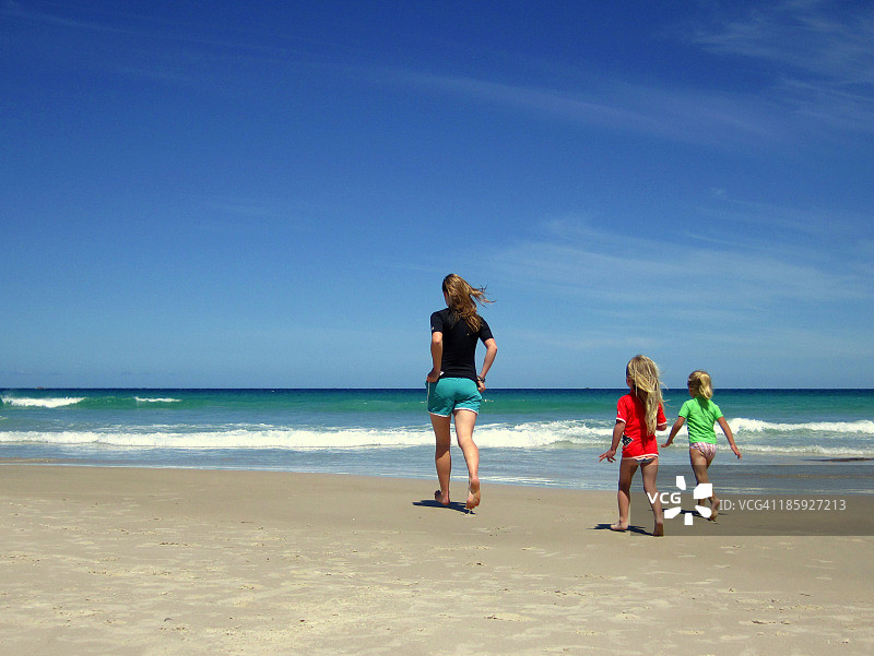 妇女和孩子们朝海滩走去图片素材