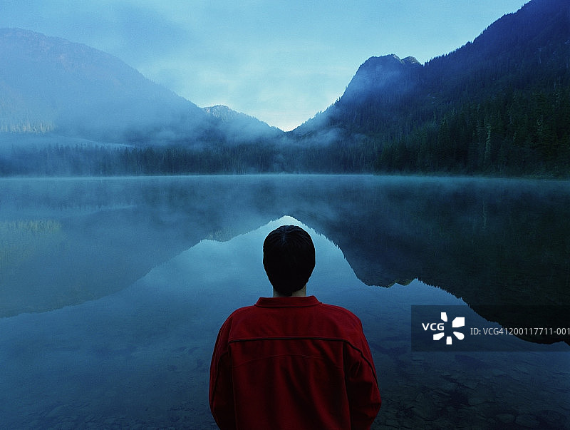 男人站在雾蒙蒙的湖边，后视镜图片素材