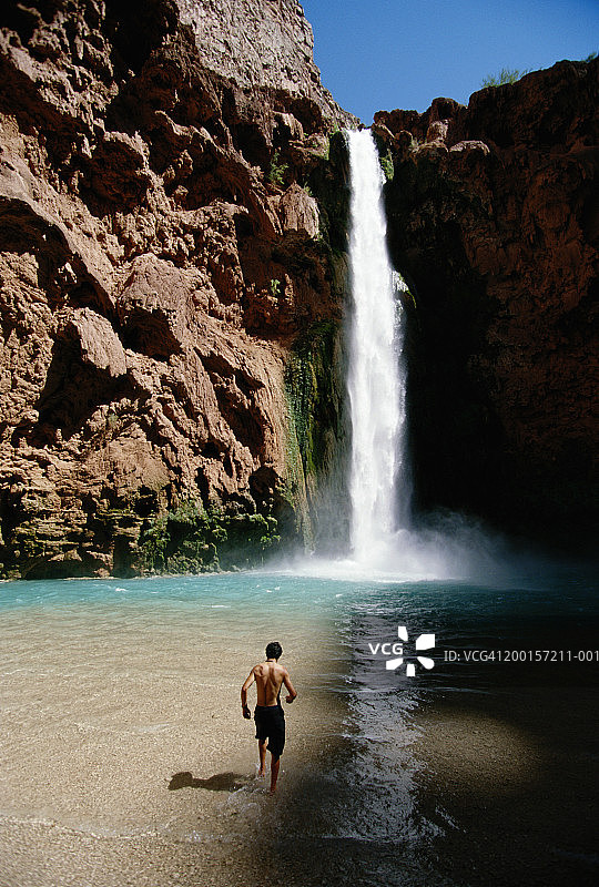 美国，亚利桑那州，哈瓦苏瀑布，男子站在瀑布下，后视图图片素材