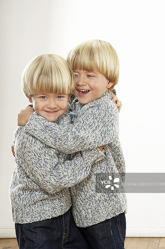双胞胎男孩(3-5)拥抱、微笑、大笑，人像图片素材