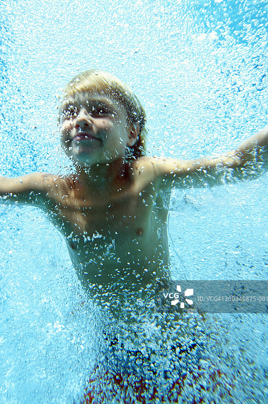 男孩(7-9)在水下游泳，近距离，低角度图片素材