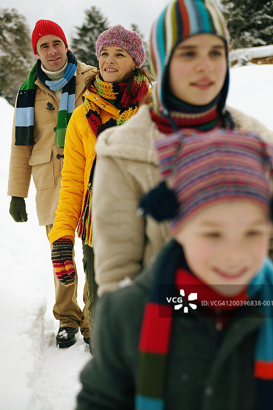 父母和孩子(9-13)在雪中行走(以父母为中心)图片素材