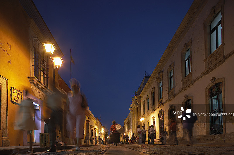 墨西哥瓦哈卡，黄昏时分，人们走在佐科拉附近的鹅卵石街道上图片素材