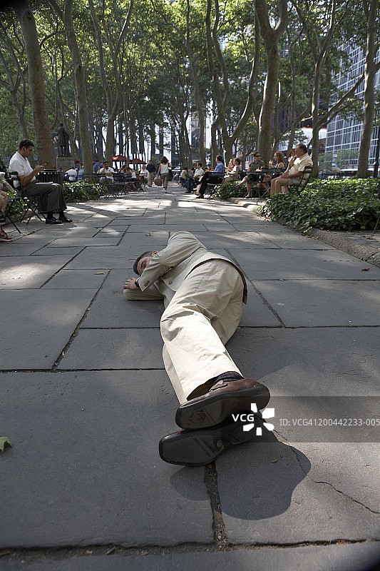 商人睡在公园的人行道上图片素材