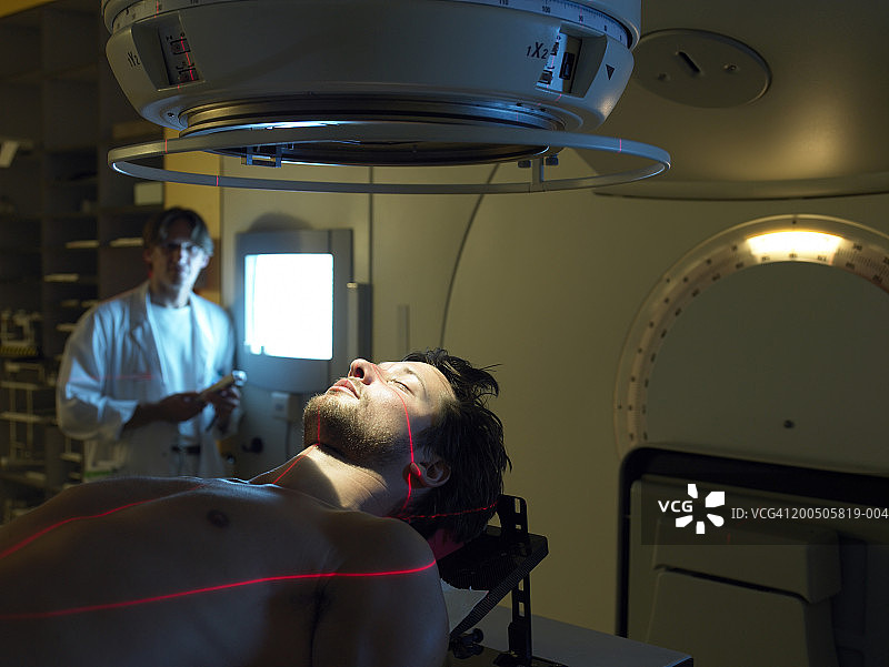 成熟的医生由男病人躺在放射床上图片素材