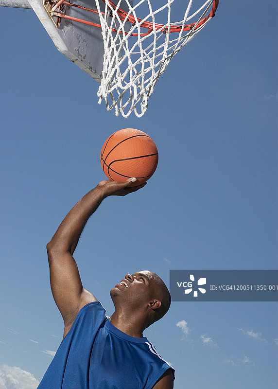 抱着篮球筐的篮球运动员图片素材