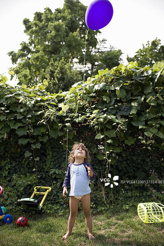 女孩(2-4)抬头看着院子里的气球，回头图片素材