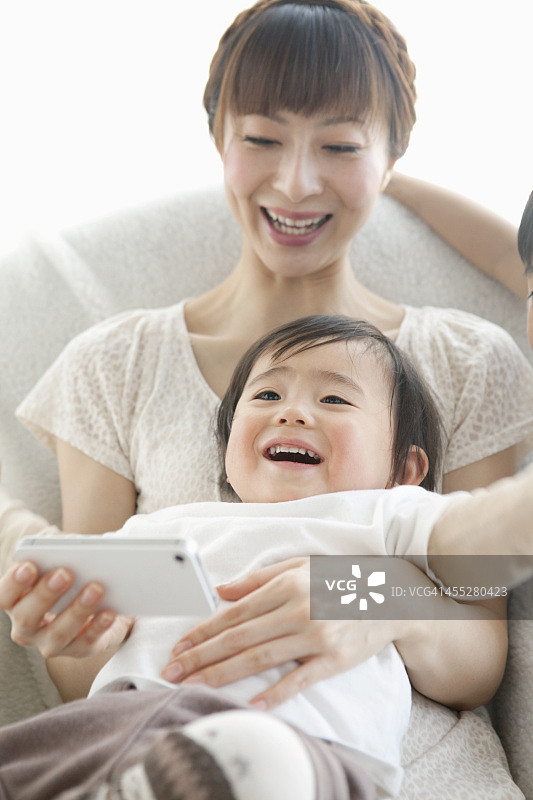 婴儿和母亲使用智能手机图片素材