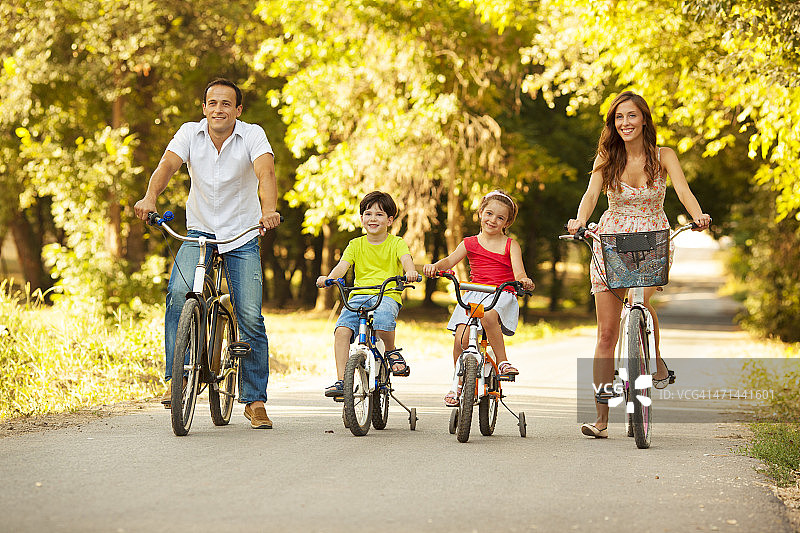 快乐家庭户外骑自行车。图片素材