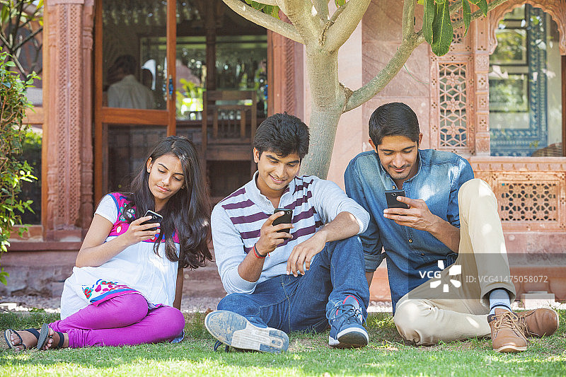 一群年轻的印度朋友使用智能手机图片素材
