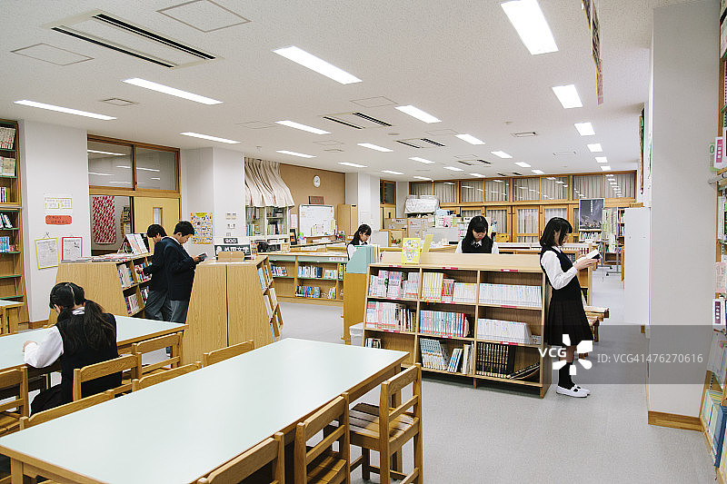 日本高中，图书馆。选择一本书，年轻的学生们图片素材