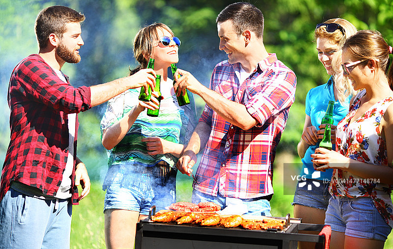 一群朋友在烧烤野餐。图片素材