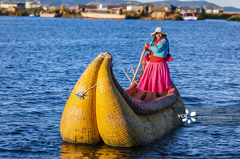 一名秘鲁妇女在Tititcaca湖的乌鲁斯浮动岛屿之间航行图片素材