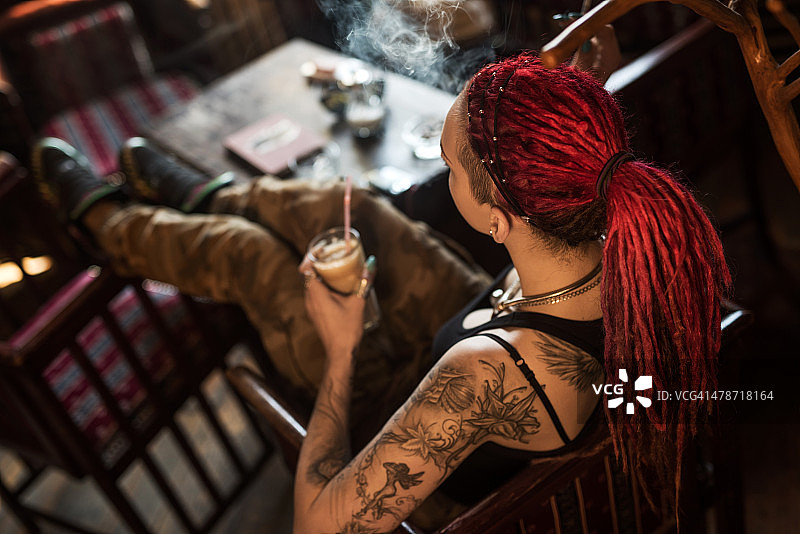 上图是一个梳着脏辫的女人在咖啡馆里。图片素材