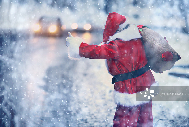 圣诞老人在雪天搭便车。图片素材