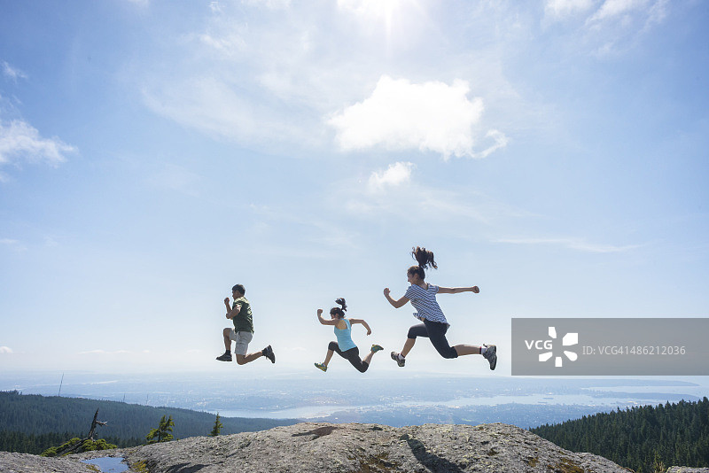 三个人在山顶、悬崖边跑跳图片素材