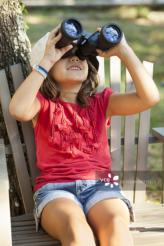 女孩用双筒望远镜仰望天空图片素材