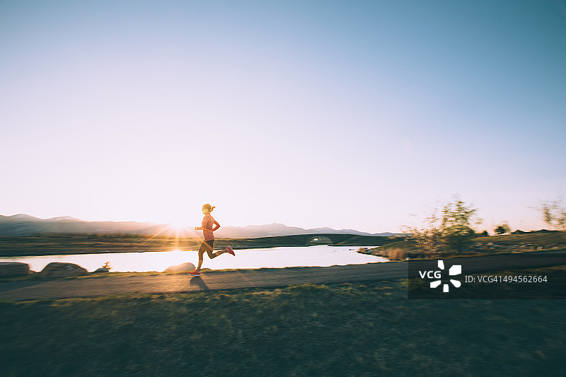 犹他州日落时分，一名女性在小路上奔跑图片素材