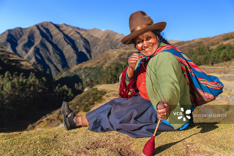 秘鲁圣谷，一名秘鲁妇女在手工纺羊毛图片素材