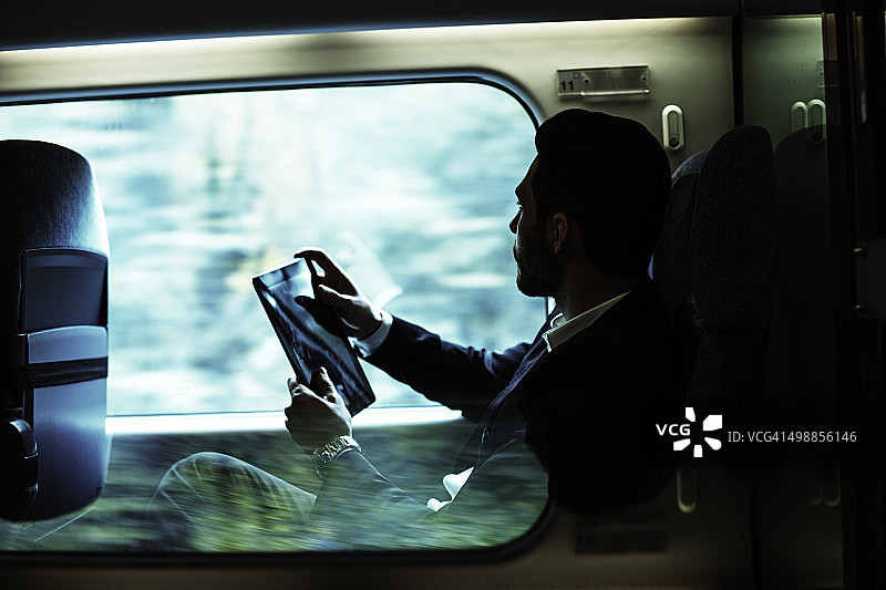 坐在火车靠窗边工作的商人图片素材