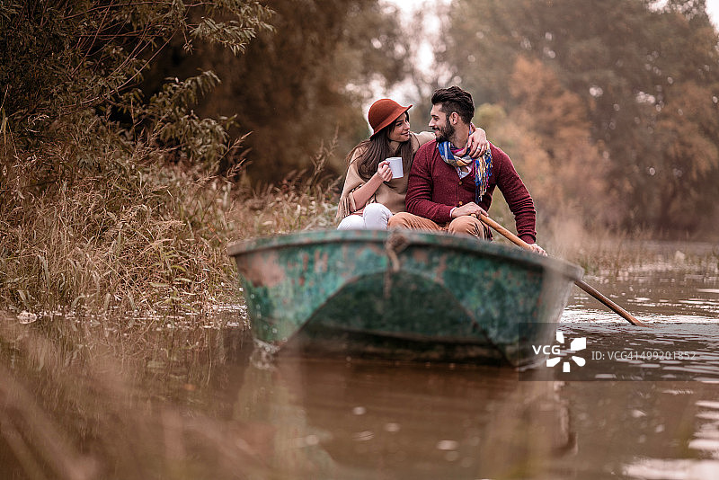 秋日，一对快乐的情侣在船上交流。图片素材