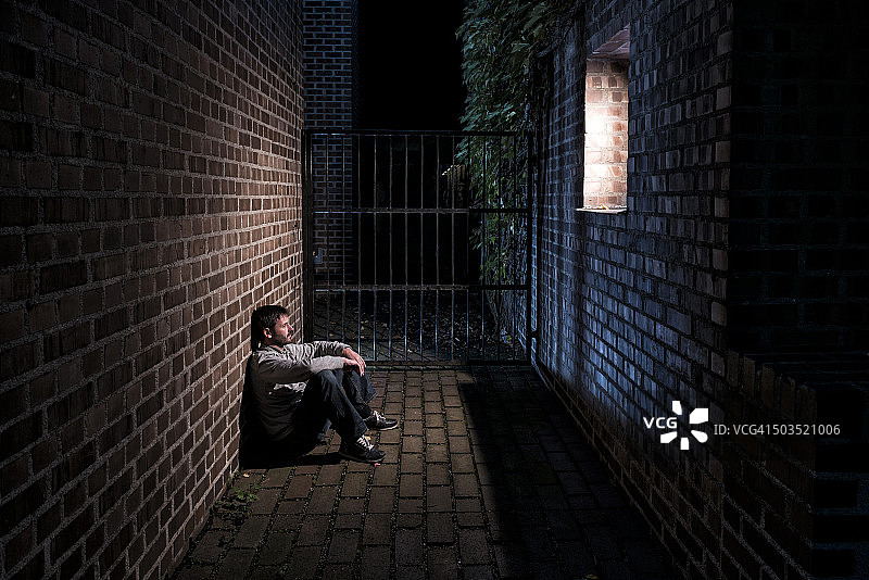 一个人晚上独自坐在窗外图片素材