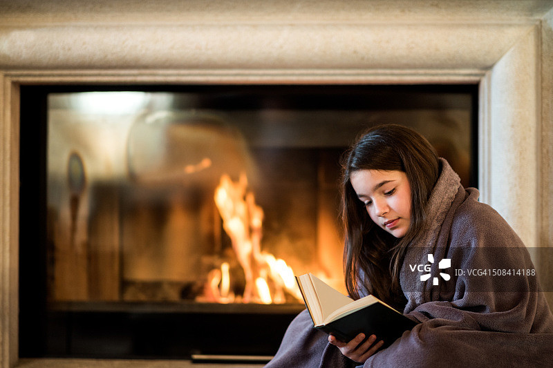 女孩在壁炉边看书图片素材