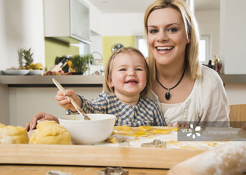 母亲和女儿在厨房烘焙的肖像图片素材