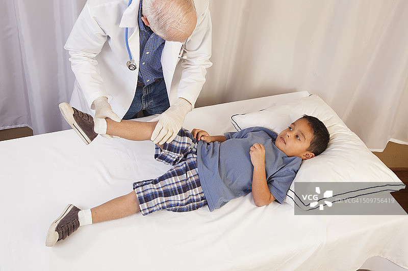 医学:拉丁裔男孩在医生办公室的检查台上。图片素材