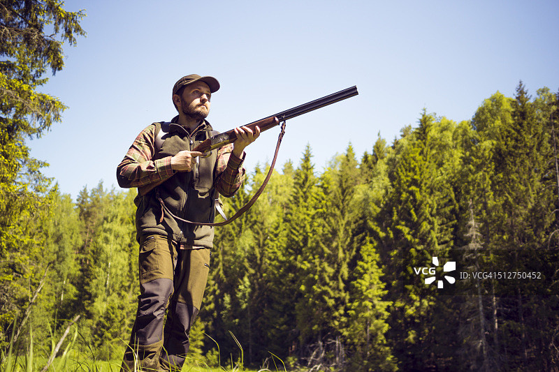 一个手持猎枪站在荒野中的人图片素材