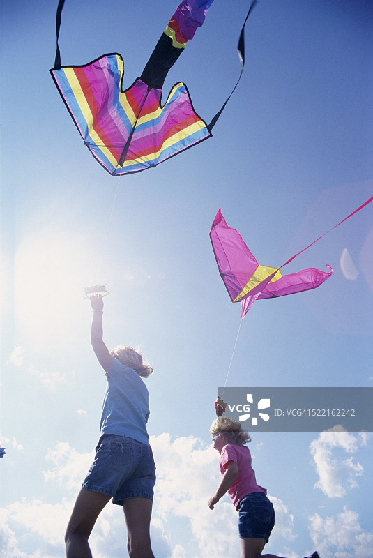 两个女孩拿着风筝跑图片素材