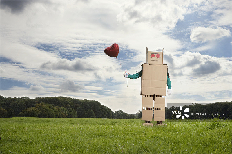 一个人装扮成拿着气球的机器人图片素材