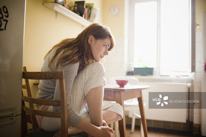一个女人坐在厨房里的肖像图片素材
