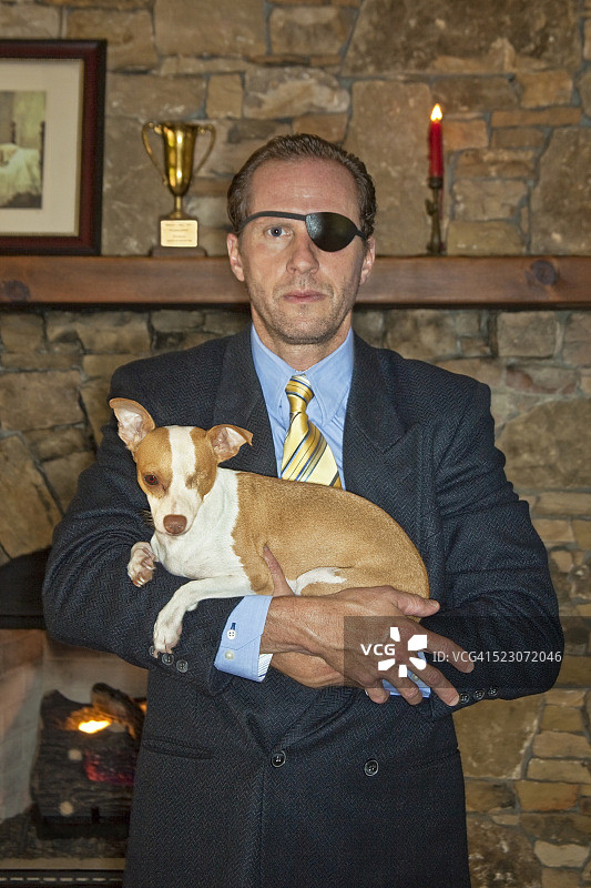 一个男人牵着他的独眼狗图片素材