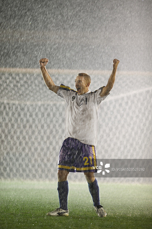 兴奋的足球运动员在雨中欣喜图片素材