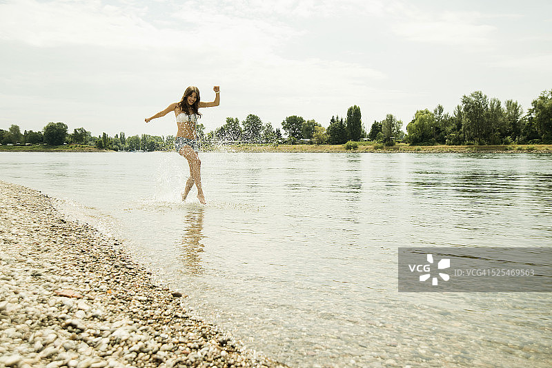 年轻女子在莱茵河水边奔跑图片素材