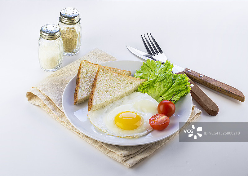 白色的餐桌上摆着简单的英式早餐。图片素材