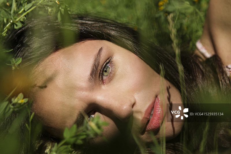 一个年轻女子躺在草地上的肖像图片素材