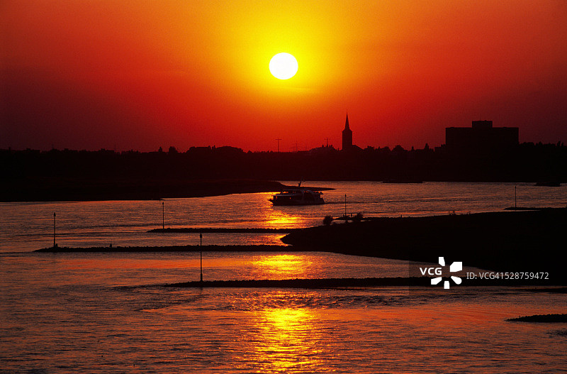 日落时分，杜塞尔多夫莱茵河上的游船图片素材
