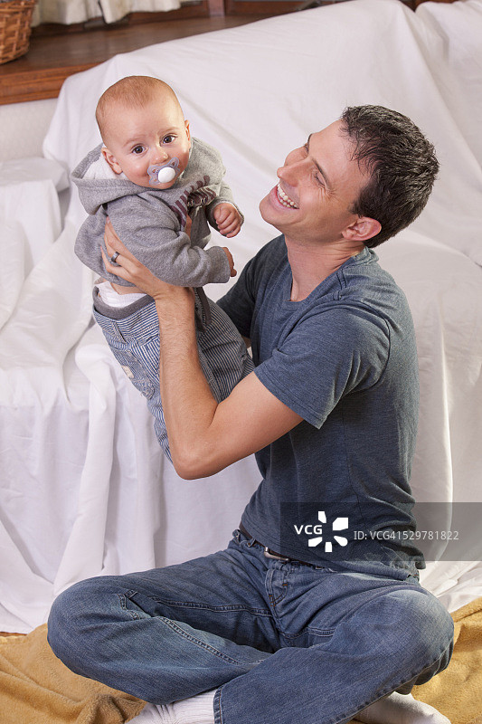 父亲和他的婴儿儿子玩图片素材