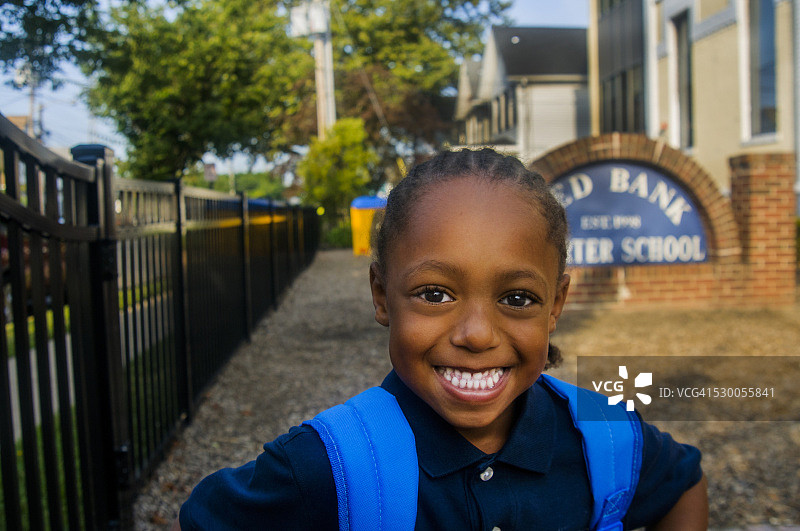在学校门口微笑的男生的肖像图片素材