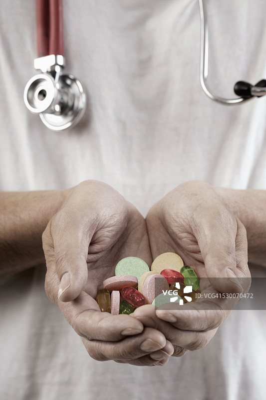 德国巴伐利亚州，一名男医生双手拿着处方药图片素材