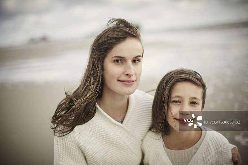 母亲和女儿在海边的肖像图片素材