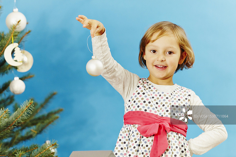 德国巴伐利亚慕尼黑，一个小女孩拿着圣诞装饰品图片素材