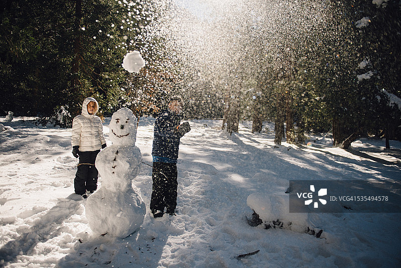 孩子们在约塞米蒂国家公园堆雪人和扔雪球图片素材