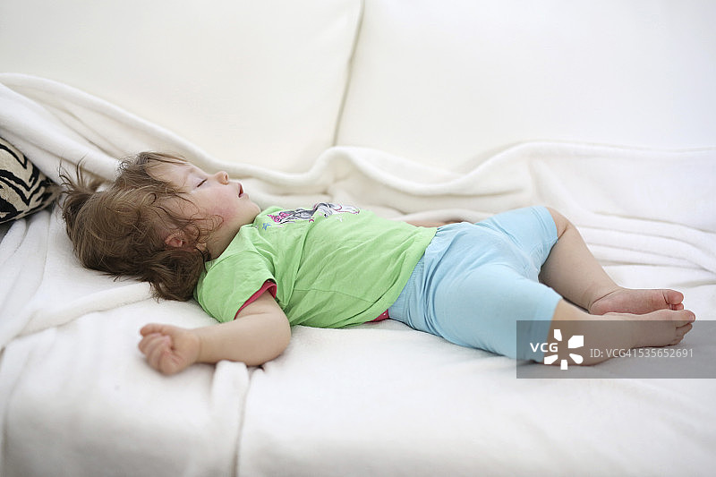小女孩睡在白色毯子上图片素材