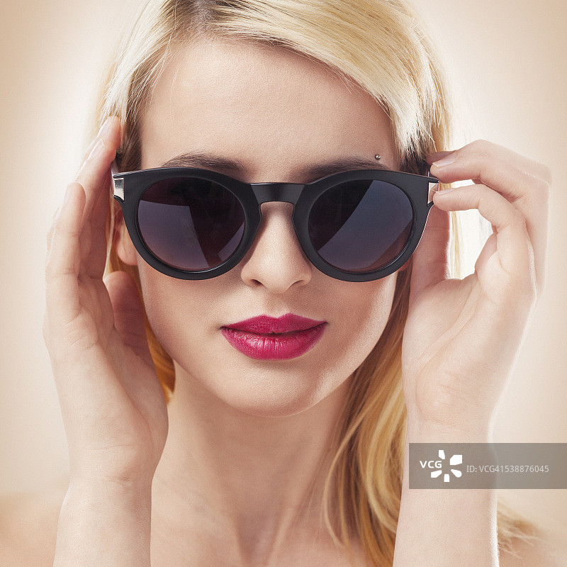 美丽的金发女人戴着太阳眼镜近距离拍摄图片素材