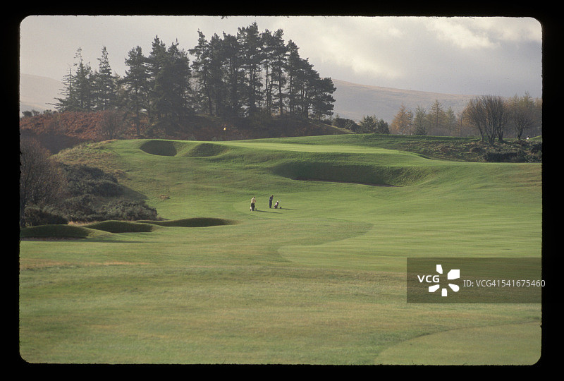观看高尔夫球场和遥远的高尔夫球手，苏格兰图片素材
